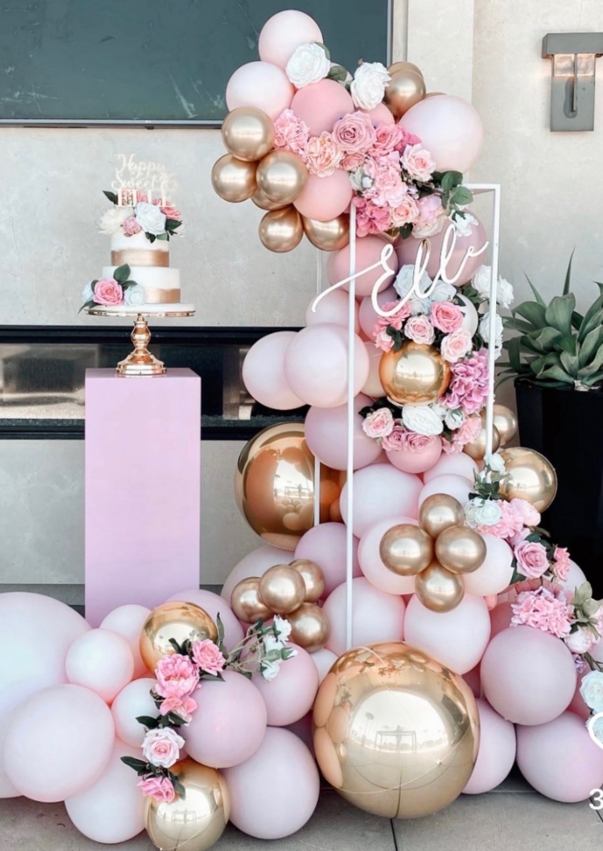 Pink and gold balloon garland with a Sweet 16 cake display